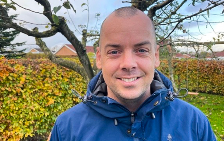 Portræt af Nikolaj Winkel, der står i sin have.