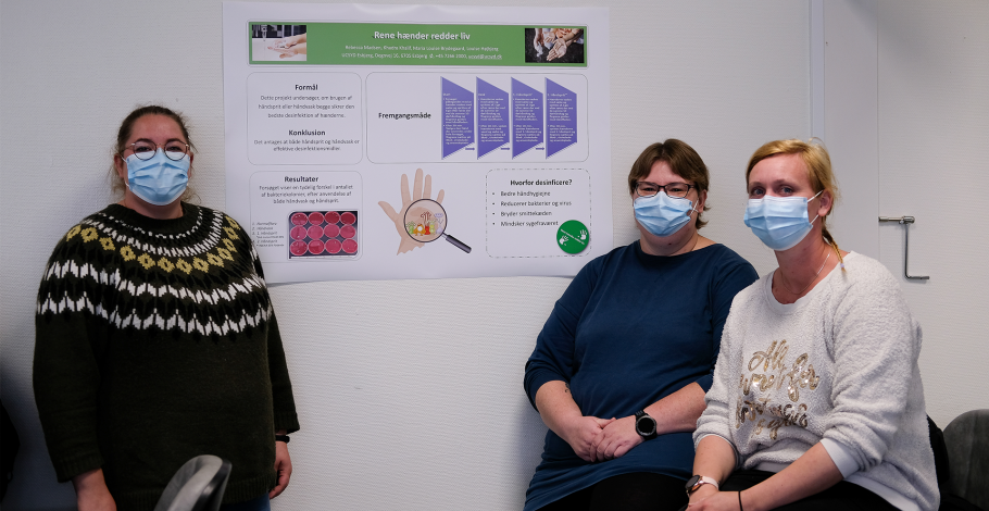 Bioanalytiker- og laborantstuderende med plakat af deres projekt "Rene hænder redder liv"